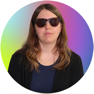 Auf dem Bild ist Frau Maria Dröst. Sie trägt eine schwarze Strickjacke und ein blaues Kleid.